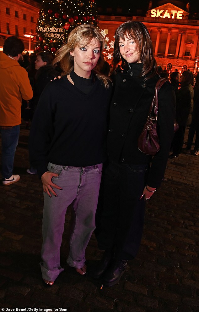 كانت ترتدي أيضًا حذاءًا عسكريًا جلديًا أسود مكتنزًا وحقيبة يد جلدية حمراء داكنة أثناء وقوفها بجانب إيزوبيل