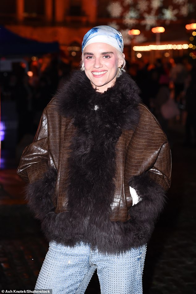 ارتدت Tigerlily سترة أنيقة مصنوعة من جلد الثعبان باللون البني ومزينة ببطانة من الفرو مع زوج من الجينز ذو الساق المستقيمة باللون الأزرق الفاتح المرصع بالجواهر وحذاء بكعب أبيض