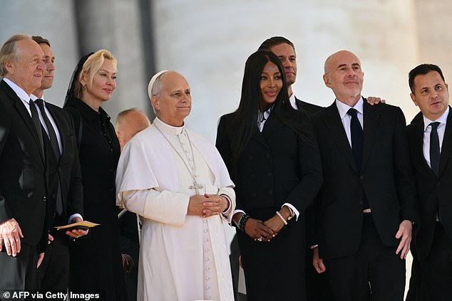 ارتدت ناعومي سترة بيبلوم سوداء مناسبة لهذه المناسبة مع تنورة ضيقة وقميص أبيض