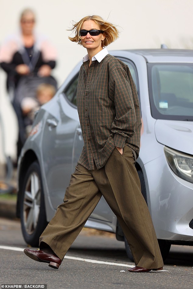 أخفت لارا شكلها الرزين تحت قميص بني منقوش فضفاض والذي يتميز أيضًا بياقة بيضاء منشا. تم ترك القميص الفضفاض دون ثنيه وتم لفه بحرية خلف خصر لارا