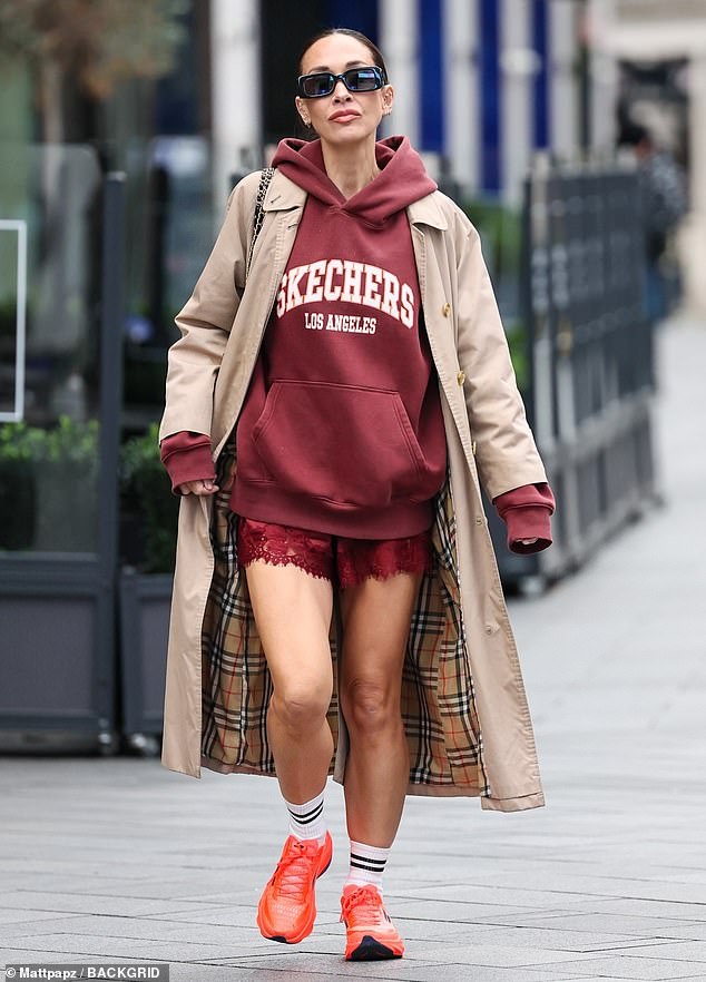 لقد أرفقت مظهرها مع كنزة حمراء ذات قلنسوة من Sketchers، مع طبقة تحت معطف واق من المطر باللون البيج الأنيق من Burberry