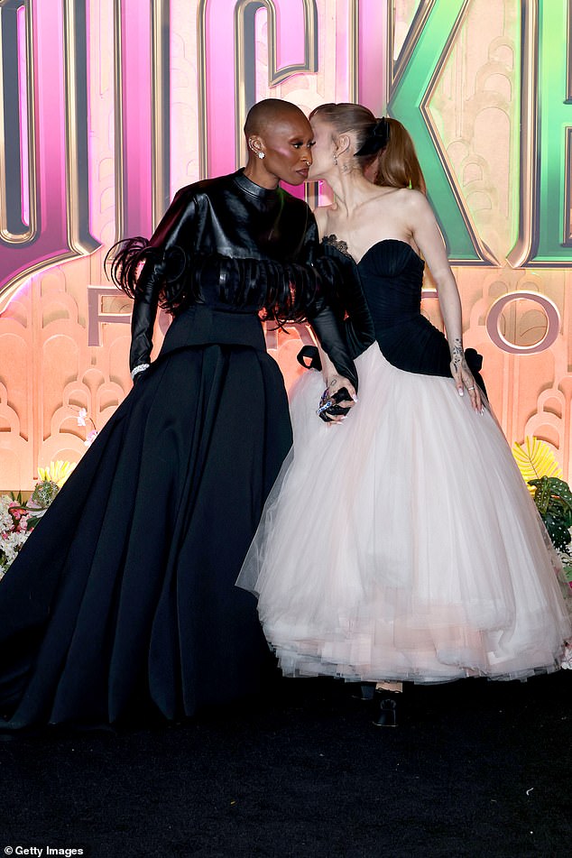 أمسك النجوم المشاركون أيديهم أثناء وقوفهم معًا على السجادة الحمراء