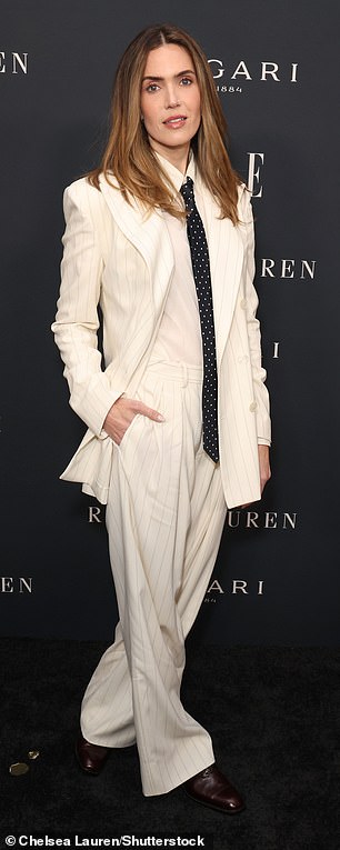 تم فصل خصلات شعرها السمراء من المنتصف وتم تصميمها بشكل مستقيم