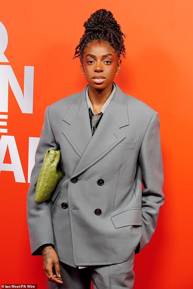 تم إكسسوار المطربة بحقيبة منسوجة باللون الأخضر