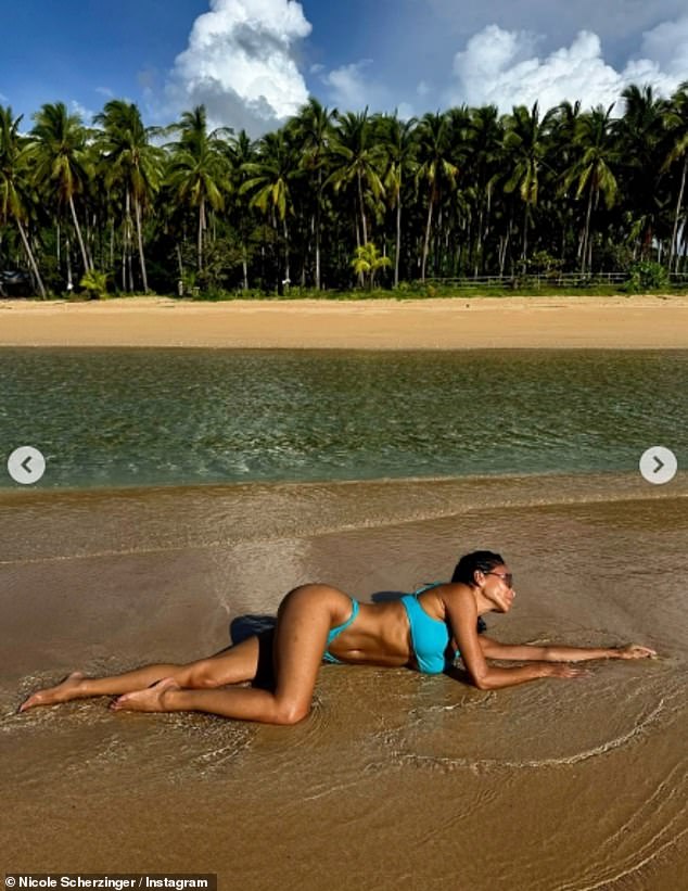 كانت تتلوى وسط الأمواج، والتفتت لتظهر بطنها المتناسق وساقيها الطويلتين، وتحمي وجهها خلف نظارة شمسية كبيرة الحجم.