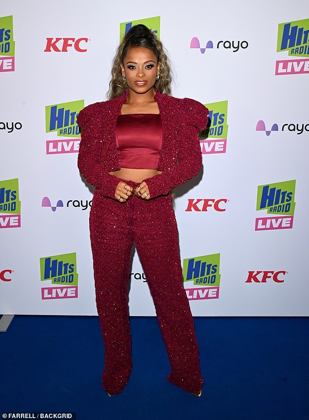 دخلت فلور، البالغة من العمر 38 عامًا، في أجواء احتفالية مرتدية قميصًا قصيرًا منسقًا باللون الأحمر اللامع وقميصًا من الساتان