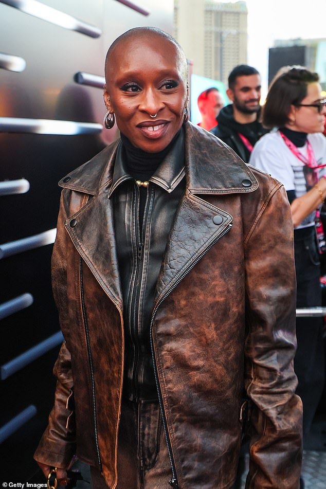 وعززت طولها بحذاء من جلد الغزال البني وحملت متعلقاتها في حقيبة يد سوداء