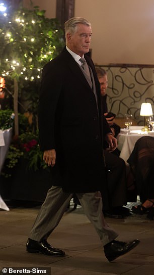 ارتدى السترة مزدوجة الصدر فوق قميص أبيض هش وربطة عنق رمادية، بينما حافظ على الدفء في معطف طويل من الصوف الأسود