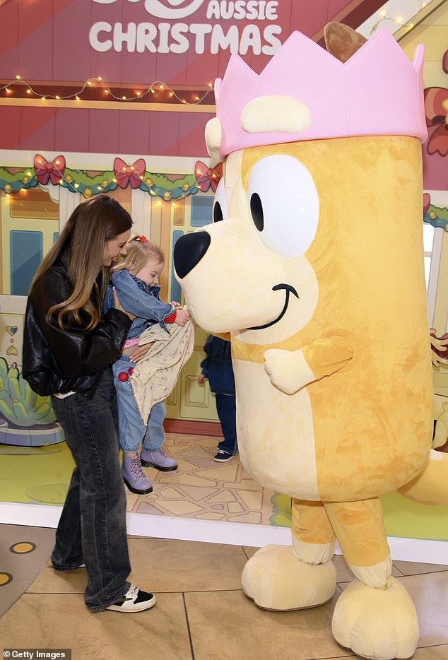 كانت مبتهجة من الأذن إلى الأذن وهي ترفع ابنتها لتحية التميمة الزرقاء في لحظة جميلة