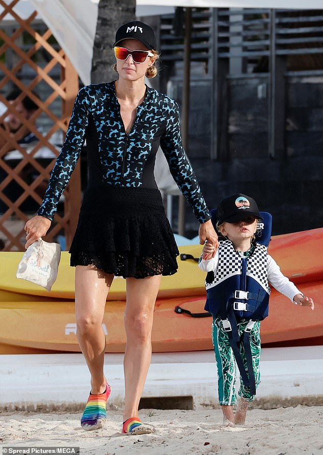 ارتدت الوريثة البالغة من العمر 44 عامًا بذلة غوص سوداء مع لمسات زرقاء وأضفت تنورة سوداء صغيرة كغطاء للرحلة. وانضم إليها ابنها فينيكس البالغ من العمر ثلاث سنوات تقريبًا