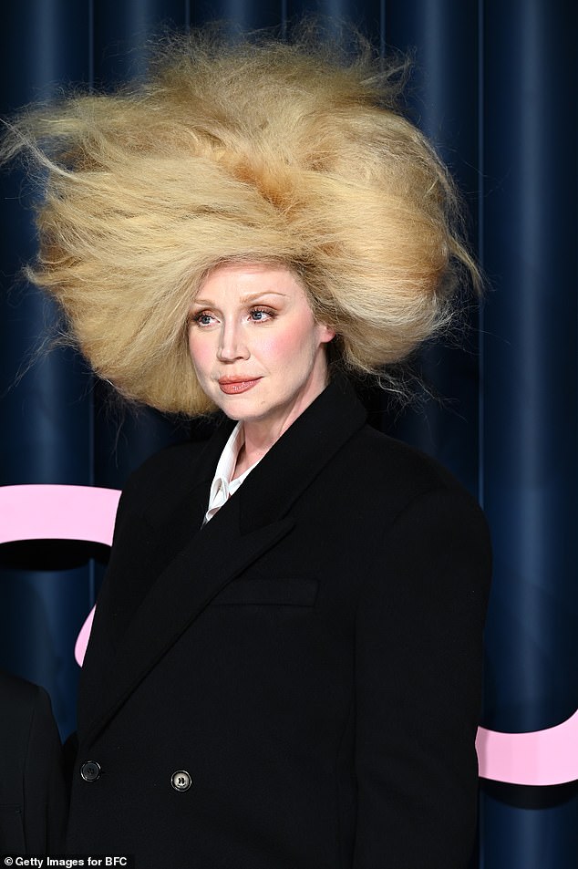 كان شعر جويندولين المستعار يرتفع فوقها ويلتف حول رأسها