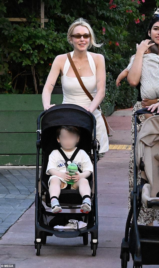 دفعت الأم الشغوفة الطفل في عربة أطفال سوداء إلى جانب صديق لديه طفل أيضًا