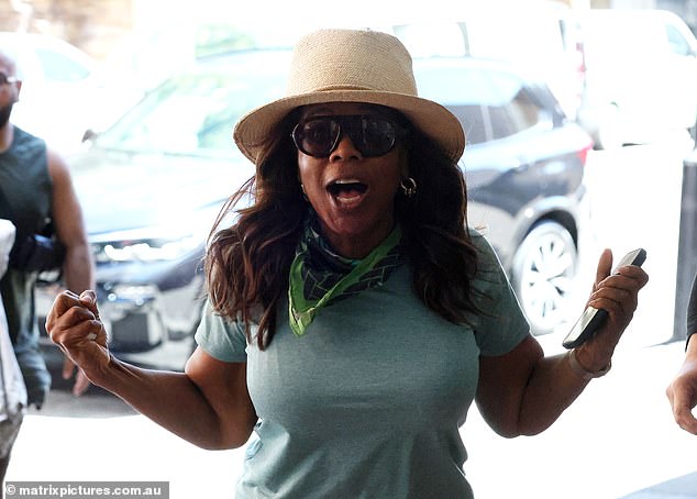 ابتسمت أوبرا وظهرت عليها تعبيرات متحمسة وهي تستقبل المتفرجين وهي في طريقها إلى مدخل الفندق