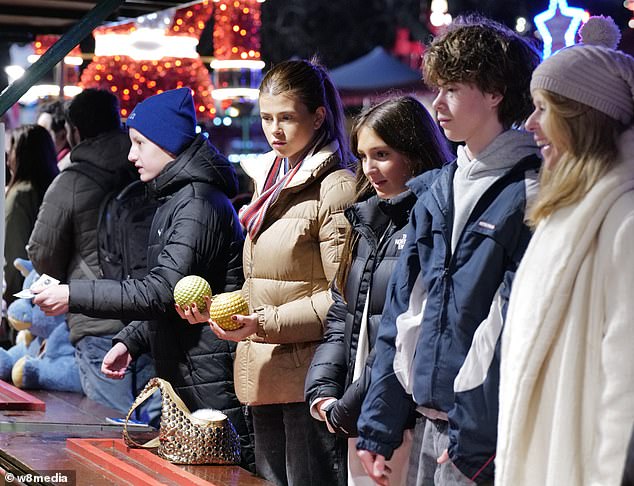 وفي الوقت نفسه، ارتدت ابنتها دارسي، 19 عامًا، سترة منتفخة باللون البيج ووشاحًا مخططًا متعدد الألوان، وانضمت إلى والدتها في لعبة الكرة.