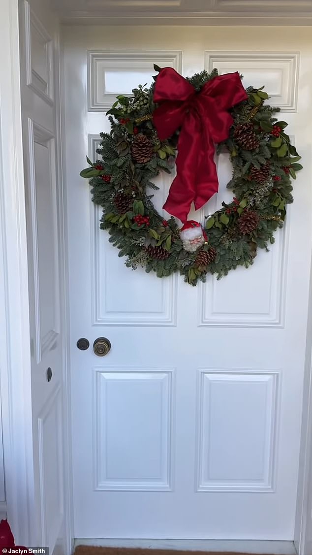 كان هناك إكليل أخضر قوي على بابها الأبيض مع قوس أحمر كبير