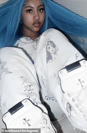 كانت ترتدي بدلة رياضية بيضاء مغطاة بطباعة جرافيكية سوداء، وأكملت المظهر بزوج من أحذية Chrome Hearts الرياضية البيضاء العالية