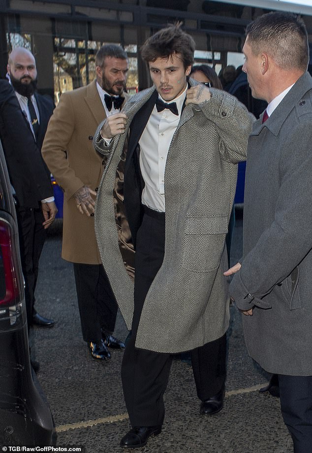 يرتدي كروز بيكهام معطفًا رماديًا طويلًا وهو في طريقه لحضور حفل زفاف هولي رامزي وآدم بيتي