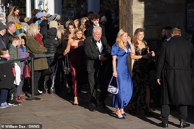 يشق المزيد من الضيوف طريقهم إلى Bath Abbey بينما تنتظر الحشود بصبر لإلقاء نظرة على العروس الخجولة