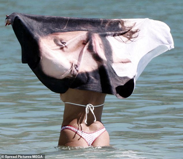 تباهت عارضة الأزياء بشخصيتها المذهلة في بيكيني قصير بطباعة الكرز بينما كانت تمرح في الماء مع الروك، 36 عامًا