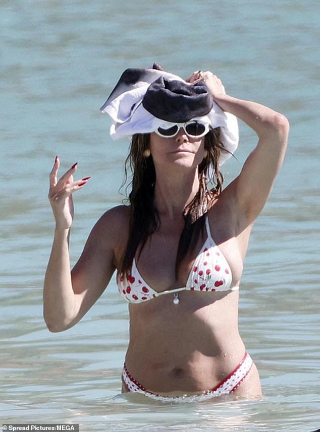 مرتدية زوجًا من النظارات الأنيقة، احتمت كلوم من أشعة الشمس الحارقة تحت منشفة الأطفال قبل أن تلفها حولها أثناء عودتها إلى الشاطئ