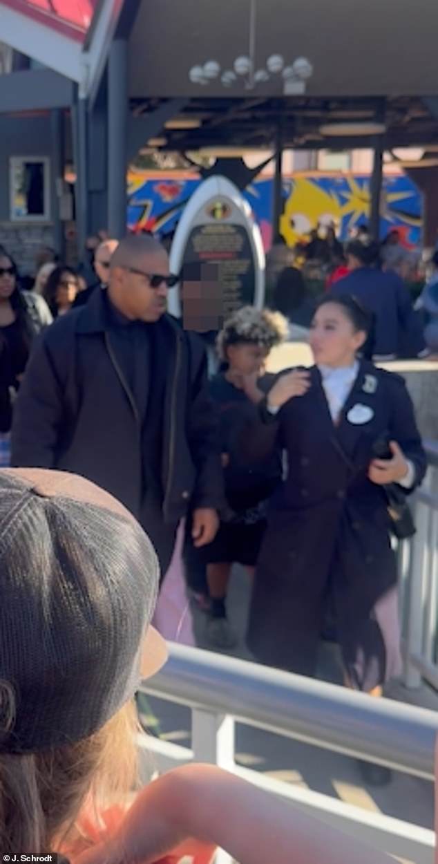 تبع القديس موظف ديزني لاند وهو يرشد المجموعة عبر الحديقة