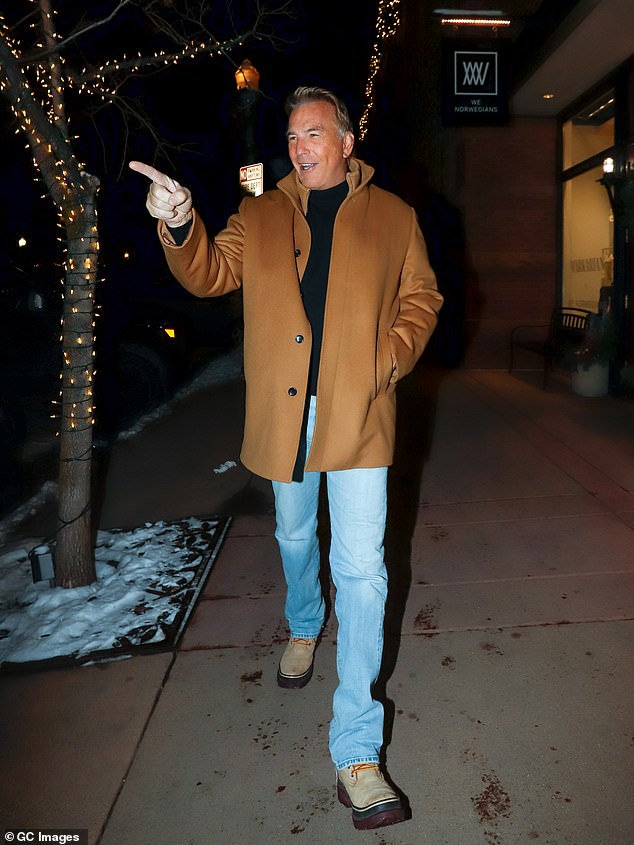 كان كيفن يرتدي معطفًا بنيًا كان يرتديه مع كنزة سوداء وجينز أزرق فاتح وحذاء أسمر