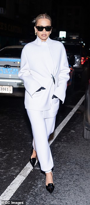 بعد الانتهاء من التدريبات، ارتدت ريتا تنسيقًا أبيض يتكون من سترة ملفوفة وبنطلون أنيق بأصفاد عند الكاحلين.