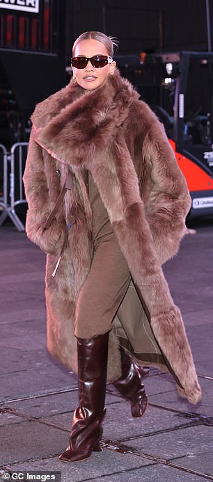 أثناء توجهها للتحضير لليوم السابق للتمرين، ارتدت ريتا معطفًا طويلًا من الفرو البني فوق طبقة من التنسيق البني المريح