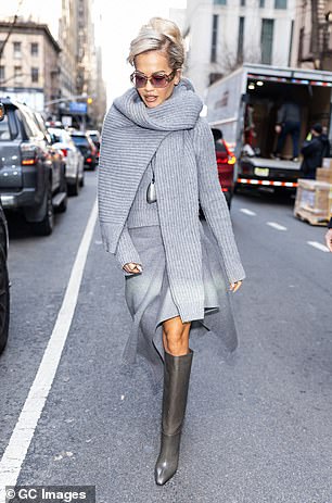 بدت ريتا أنيقة دون عناء في حذاء رمادي يصل إلى الركبة وسترة ووشاح