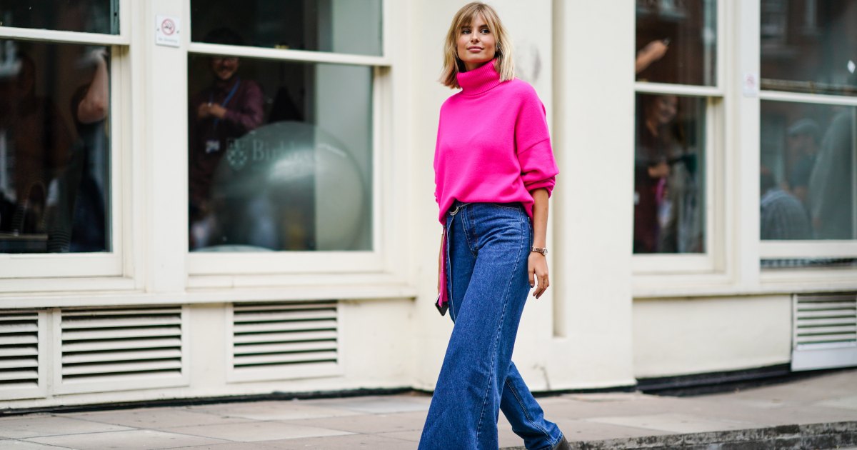 ترتدي Xenia Adonts بلوفرًا من الصوف ذو الياقة المدورة باللون الوردي النيون، وسروال جينز أزرق بساق واحدة واسعة، وحذاء ذو نعل سميك رمادي، خلال أسبوع الموضة في لندن سبتمبر 2019 في 16 سبتمبر 2019 في لندن، إنجلترا.