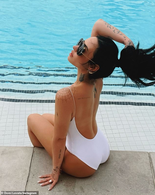 وفي صورة أخرى، لعبت المرشحة لجائزة جرامي مرتين بشعر ذيل الحصان بينما كانت ترتدي ملابس سباحة بيضاء من قطعة واحدة عارية الذراعين بجانب حمام السباحة.