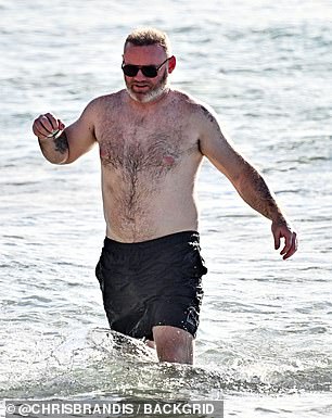 هز واين بلا قميص زوجًا من السراويل القصيرة السوداء