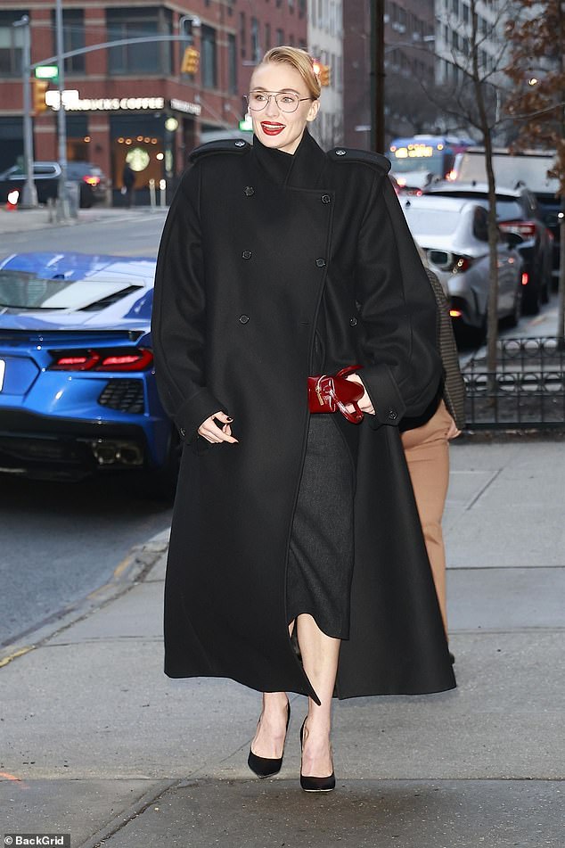 كانت الأم لطفلين، البالغة من العمر 29 عامًا، ترتدي نظارة ذات إطار رفيع ومعطفًا أسود كبير الحجم به أكتاف معززة وكتاف ضخمة.