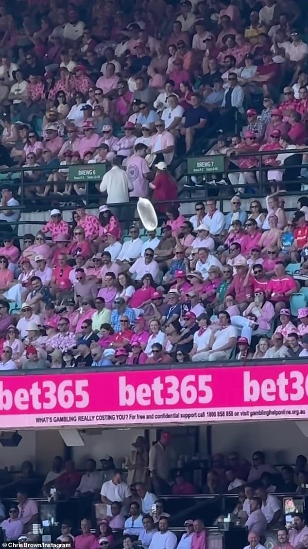 انتقل الدكتور كريس إلى موقع Instagram يوم الأربعاء، حيث شارك مقطعًا يظهره وهو جالس في مدرجات SCG، ولكن بدلاً من مراقبة الحدث، كان مذهولًا بالواقي الذكري المنتفخ الذي كان يتطاير بسهولة مع النسيم