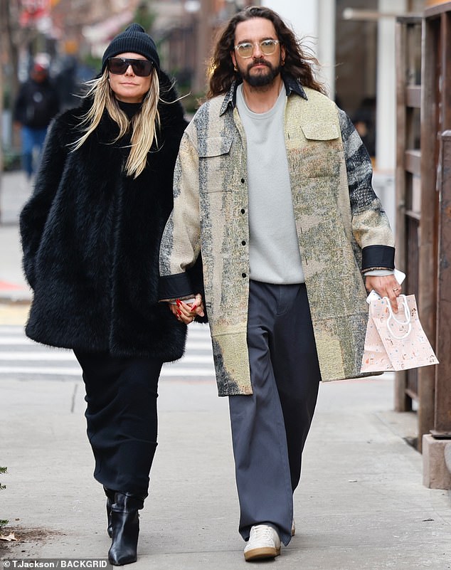 ارتدت هايدي معطفها فوق فستان أسود ضيق، مع حذاء جلدي أسود