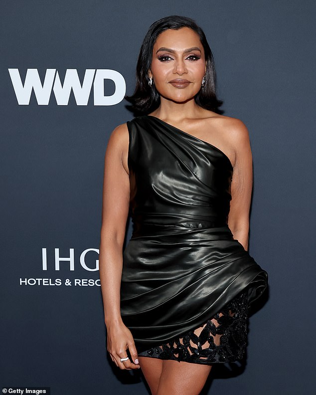 تم قلب الشعر البني المقصوص لشبة المكتب من الأطراف لتأطير وجهها الذي لا تشوبه شائبة