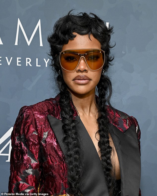 كان شعرها الأسود المتموج مضفوراً في ضفائر تتدفق حتى خصرها