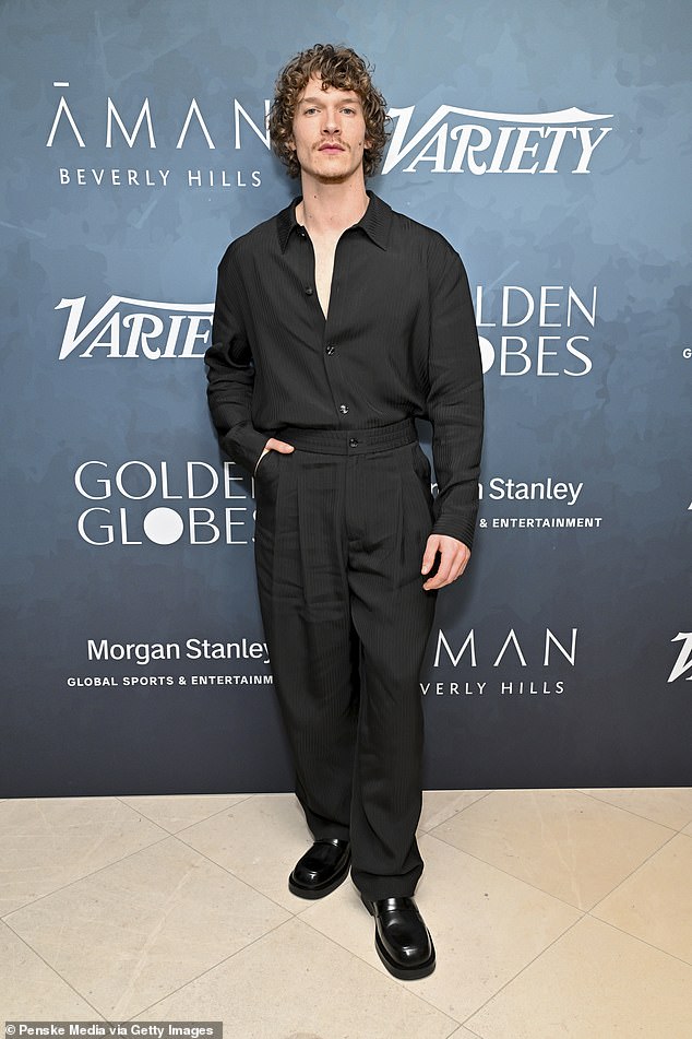 التنافس المحتدم كونور ستوري مشتعلًا من أجل هواة التصوير في قميص أسود أنيق بأزرار مدسوس في بنطال عالي الخصر