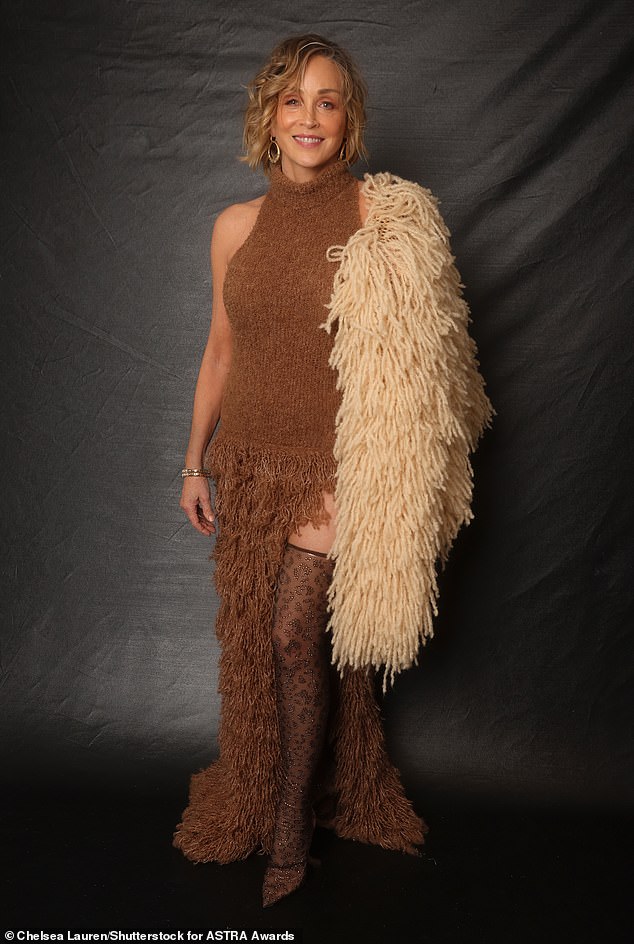 أظهرت شارون جمالها الدائم في فستان بني بطول الفخذ مع جوارب سوداء بطبعة جلد الفهد.