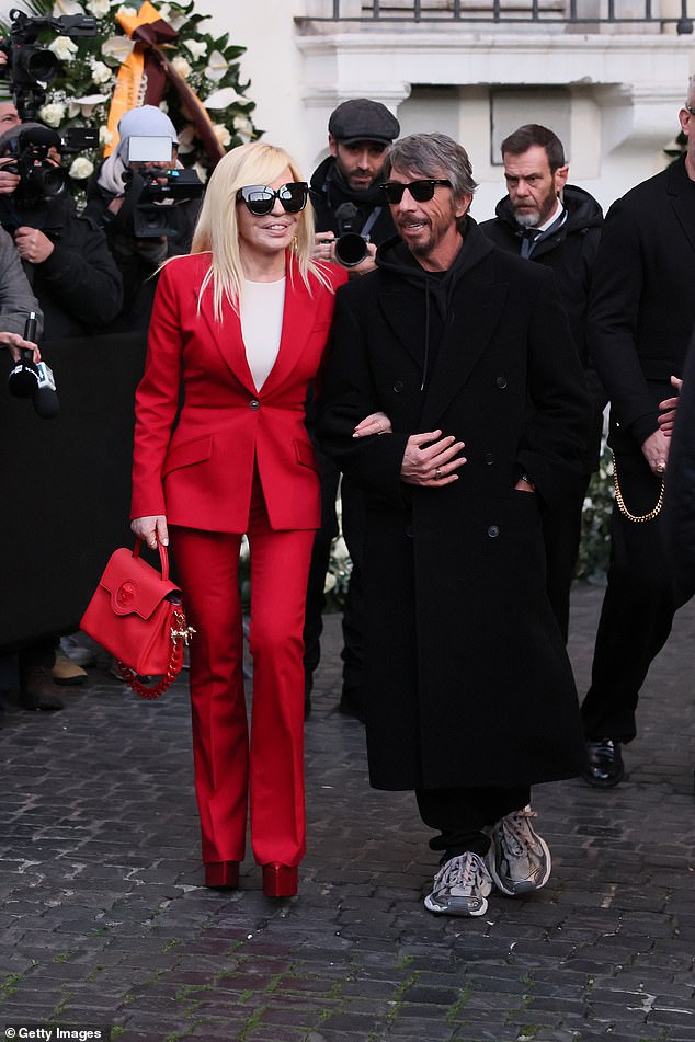 في هذه الأثناء، ظهر بيير بمظهر غير رسمي أنيق يرتدي معطفًا أسود مزدوج الصدر، مقترنًا بغطاء رأس رمادي داكن وحذاء رياضي مكتنز، بينما كان يربط ذراعيه مع دوناتيلا.