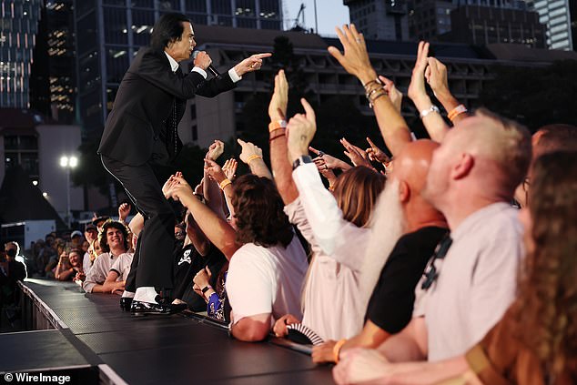 كان كيف يرتدي بدلة سوداء حادة وقميصًا أبيض، وقد ظهر بشكل ملفت للنظر بينما كان يسير على مدرج ضيق يمتد في عمق الحشد، حاملاً الميكروفون في يده، وذراعه الحرة تمتد لشبك أصابع المشجعين.