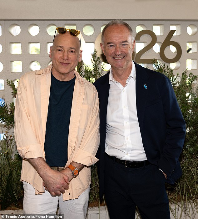 ابتسم الممثل أثناء التقاط الصور إلى جانب رئيس اتحاد التنس الأسترالي كريس هاروب (على اليمين) قبل المشاركة في المباراة