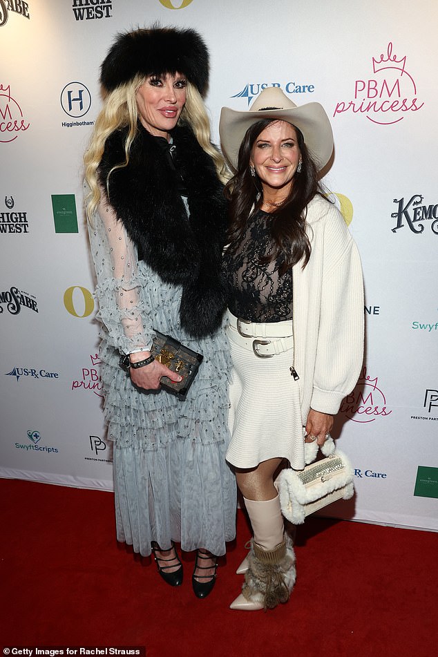 ارتدت نجمة تلفزيون الواقع شعرها الأشقر البلاتيني المتتالي في الأقفال. في الصورة مع المنتج راشيل شتراوس