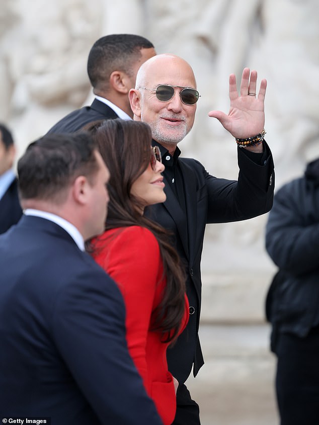 برزت ببدلة تنورة حمراء نابضة بالحياة عندما وصلت جنبًا إلى جنب مع زوجها الملياردير جيف قبل العرض التقديمي في الساعة 10:00 صباحًا، وهو الأول من بين 49 عرضًا يقام على مدار أربعة أيام متتالية في العاصمة الفرنسية.