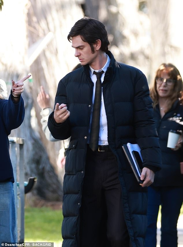 أخفى ممثل Spider-Man الكثير من زيه، الذي يتكون من قميص أبيض وربطة عنق سوداء ضيقة وسروال، تحت معطف منتفخ مريح.