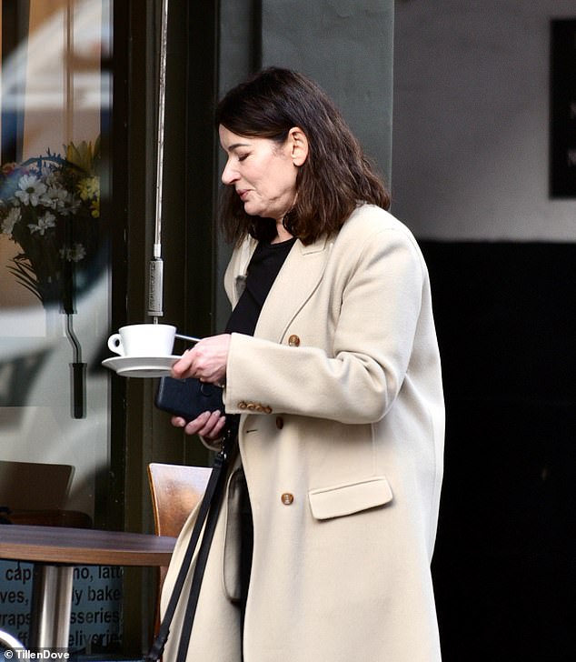 حملت حبة البركة مشروبها الساخن بعناية إلى طاولة خارجية في المقهى