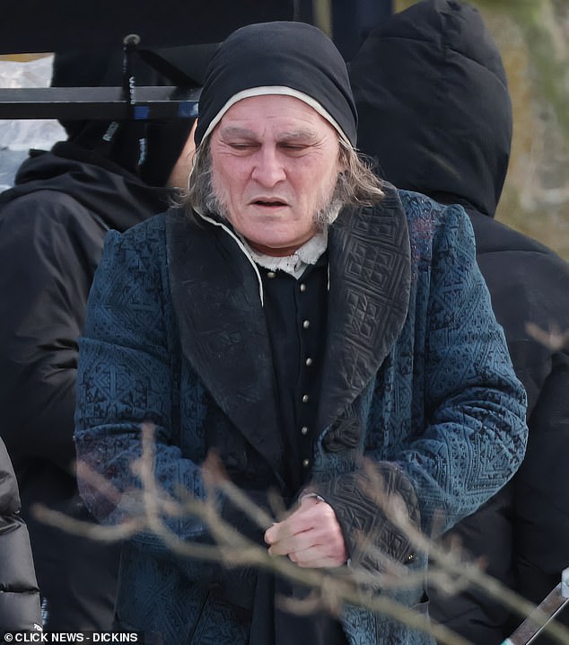 كان يرتدي معطفًا أزرق اللون وقبعة سوداء، وسوالف رمادية طويلة