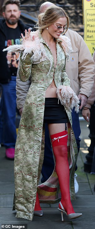 أكملت روبي مظهرها بتنورة قصيرة سوداء تصل إلى الفخذ وجوارب حمراء بذيئة، وجذبت الأضواء حتماً خلال ظهورها العلني الأخير.