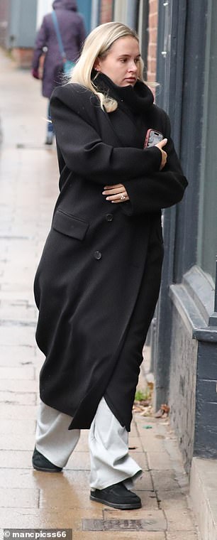 أخفت مؤسسة Maebe نتوء طفلها بينما كانت ملفوفة بالدفء في معطف أسود