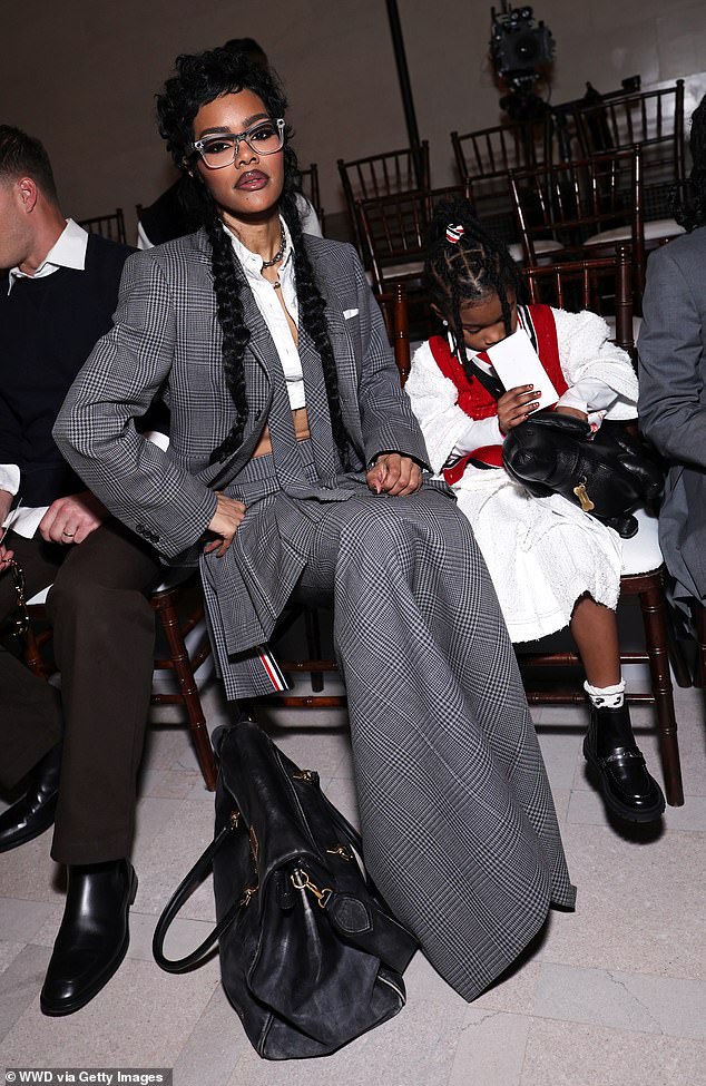 ارتدت تايلور شعرها الداكن في ضفيرتين طويلتين أثناء جلوسها في الصف الأمامي